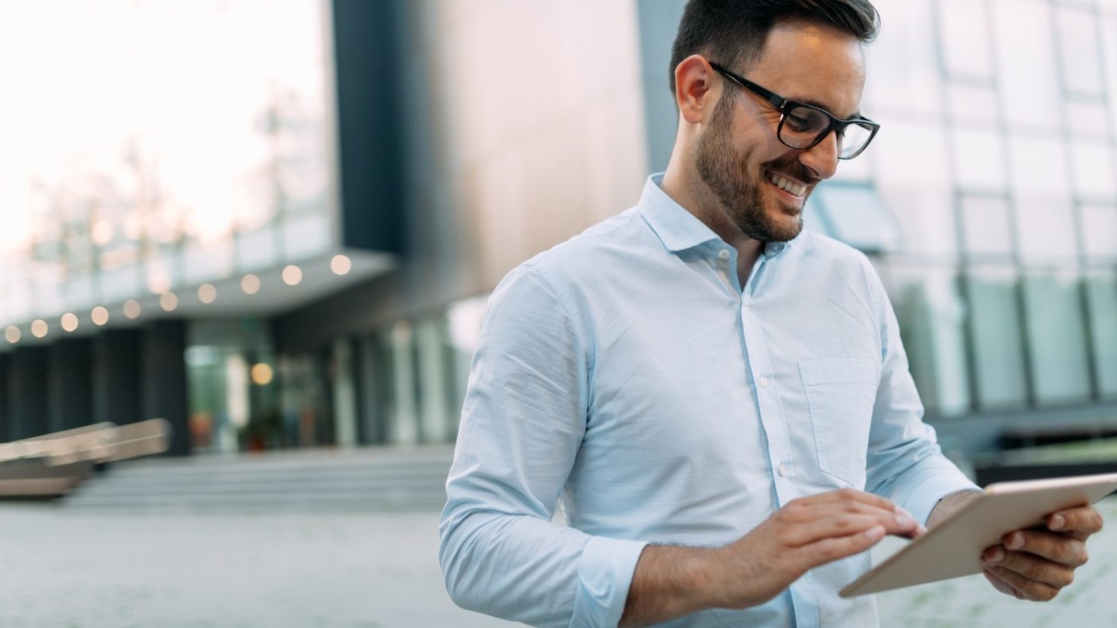 portrait-of-businessman-in-glasses-holding-tablet-AWVHCJU-1600x900